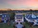 Stunning aerial view of luxurious homes with manicured lawns and golf course views during a colorful sunset at 2640 Crooked Stick Ln, Mount Pleasant, SC 29466
