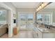 Light-filled bathroom with dual sinks, granite countertops, and sliding doors to a private outdoor space at 2640 Crooked Stick Ln, Mount Pleasant, SC 29466