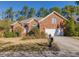 Charming brick home featuring a well-manicured lawn, mature landscaping, and an attached two-car garage at 2800 Waterpointe Cir, Mount Pleasant, SC 29466