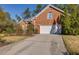 Exterior view of attached two-car garage, showcasing the concrete driveway and mature landscaping at 2800 Waterpointe Cir, Mount Pleasant, SC 29466