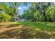 Lush, sprawling backyard with a covered patio area, mature trees, and ample lawn space at 2988 Bolton Rd, Charleston, SC 29414