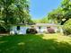 Charming single story home featuring a well manicured lawn with mature trees and colorful landscaping at 2988 Bolton Rd, Charleston, SC 29414