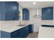 Bright kitchen with blue cabinets, stainless vent hood and white countertops at 3364 Osceola St, North Charleston, SC 29405