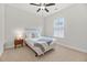 A well-lit bedroom with carpet, a bed, a bedside table with a lamp, and a window at 361 Ripple Park Dr, Summerville, SC 29486
