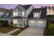 Two-story home featuring a welcoming front porch and a two-car garage at dusk at 361 Ripple Park Dr, Summerville, SC 29486