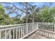 This is a deck with a white railing that overlooks lush greenery and trees under a blue sky at 3635 Pompano Ct, Seabrook Island, SC 29455