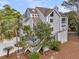 Stately multi-level home with mature landscaping, wood stairs and light blue siding at 3635 Pompano Ct, Seabrook Island, SC 29455