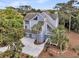 Coastal style home with a circular driveway, lush green trees, and natural outdoor space at 3635 Pompano Ct, Seabrook Island, SC 29455