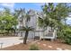 Beautiful home featuring a tower structure, lush landscaping, and a charming outdoor deck at 3635 Pompano Ct, Seabrook Island, SC 29455