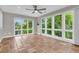 Bright, open living room with terra cotta flooring, a ceiling fan and multiple, large picture windows at 3635 Pompano Ct, Seabrook Island, SC 29455
