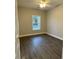 Well-lit bedroom featuring dark vinyl floors, a window, and neutral paint, creating a calm ambiance at 419 Ravenwood Rd, Walterboro, SC 29488