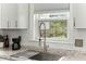 Kitchen detail showcases a stainless steel sink, white cabinets, subway tile backsplash and outdoor view at 49 Crosscreek Dr, Charleston, SC 29412