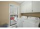 Functional laundry room with washer, dryer, and built-in cabinets next to an outdoor patio at 49 Crosscreek Dr, Charleston, SC 29412