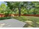 Large backyard featuring green grass, a patio area, a fire pit, and mature trees at 5418 Percival Ln, Charleston, SC 29420