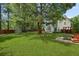 Expansive backyard featuring lush green grass, mature trees, a fire pit, and a playground at 5418 Percival Ln, Charleston, SC 29420
