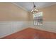 Dining room with wood floors, decorative wainscoting, a view of the window and chandelier at 5418 Percival Ln, Charleston, SC 29420