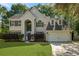 Two story home featuring a manicured front yard, two-car garage and mature trees at 5418 Percival Ln, Charleston, SC 29420