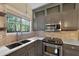 Charming kitchen features updated appliances, painted cabinets, quartz countertops, and brick backsplash at 5418 Percival Ln, Charleston, SC 29420