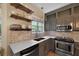 Updated kitchen boasts stainless steel appliances, painted cabinets, brick backsplash, and open shelving at 5418 Percival Ln, Charleston, SC 29420