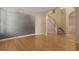 Open-concept living room features hardwood floors, a staircase, and a mountain range mural on the wall at 5418 Percival Ln, Charleston, SC 29420