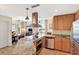 Gourmet kitchen with granite counters, island cooktop, stainless appliances, and adjacent living space at 5802 Palmetto Dr # B-501, Isle of Palms, SC 29451