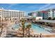 Stunning view of the resort's pool area, featuring multiple pools, lounge chairs, and palm trees at 5802 Palmetto Dr # B-501, Isle of Palms, SC 29451