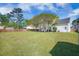 Large backyard featuring green grass, a wooden fence, and mature trees at 603 Curing Ct, Moncks Corner, SC 29461