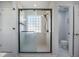 Modern bathroom with a glass enclosed shower and glass block window for natural light at 603 Curing Ct, Moncks Corner, SC 29461