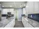 Modern kitchen with white cabinets, grey tile flooring, stainless appliances, and attractive backsplash at 603 Curing Ct, Moncks Corner, SC 29461