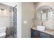 Modern bathroom featuring sleek vanity, decorative shower with geometric design, and round mirror at 76 Radcliffe St, Charleston, SC 29403