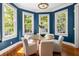 Charming dining room with blue walls, hardwood floors, chandelier, and four windows at 76 Radcliffe St, Charleston, SC 29403