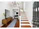 Bright foyer features hardwood floors, staircase, modern light fixture, and decor at 76 Radcliffe St, Charleston, SC 29403