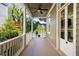 Covered porch with ceiling fan, white columns, and view of a lush backyard at 76 Radcliffe St, Charleston, SC 29403