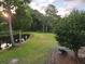 Picturesque backyard featuring a serene pond, lush green lawn, and mature trees at 7997 Doar Rd # C-3, Awendaw, SC 29429