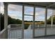 Marsh views from a screened-in porch with white columns and white railings, plus grey wood floors at 7997 Doar Rd # C-3, Awendaw, SC 29429