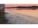 Scenic water view at dusk, featuring pink sunset colors, a dock, and distant trees reflected in the water at 7997 Doar Rd # C-3, Awendaw, SC 29429