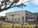 Two-story building with a Golf Pro Shop, covered walkways, palm trees, and golf carts at 855 Club Cottage Rd, Edisto Island, SC 29438