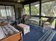 Relaxing screened-in sunroom with comfortable seating, offering a peaceful space to enjoy the outdoors at 855 Club Cottage Rd, Edisto Island, SC 29438