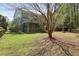 Lush backyard with mature trees and a screened-in porch creates a peaceful outdoor oasis, along with a fire pit at 8566 Royal Palm Ln, North Charleston, SC 29420
