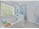 Bright bathroom features a soaking tub, glass shower, and a large window for natural light at 8566 Royal Palm Ln, North Charleston, SC 29420