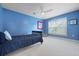 Bright bedroom features a ceiling fan, window, and blue walls at 8566 Royal Palm Ln, North Charleston, SC 29420