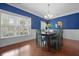 Bright dining room with hardwood flooring, modern lighting, and large windows offer a warm ambiance at 8566 Royal Palm Ln, North Charleston, SC 29420