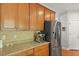 Kitchen area with stainless steel refrigerator, wood cabinets, and granite countertops at 8566 Royal Palm Ln, North Charleston, SC 29420