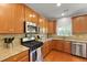 Spacious kitchen with stainless steel appliances, granite counters, wood cabinets, and window over sink at 8566 Royal Palm Ln, North Charleston, SC 29420