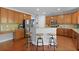 Well-lit kitchen with wooden cabinets, granite countertops, stainless steel appliances, and breakfast bar seating at 8566 Royal Palm Ln, North Charleston, SC 29420