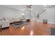 Open-concept living room with hardwood floors, large sectional, and staircase leading to the second floor at 8566 Royal Palm Ln, North Charleston, SC 29420