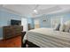 Sun-filled main bedroom with hardwood floors, a TV, and a tray ceiling at 8566 Royal Palm Ln, North Charleston, SC 29420