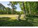 Inviting backyard with pristine landscaping, mature trees, and lawn furniture at 8642 W Fairway Woods Dr, North Charleston, SC 29420