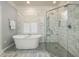 Bright bathroom featuring a soaking tub, glass-enclosed shower, and marble tile at 8642 W Fairway Woods Dr, North Charleston, SC 29420