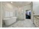Elegant bathroom featuring a soaking tub, glass-enclosed shower, marble floors, and walk-in closet at 8642 W Fairway Woods Dr, North Charleston, SC 29420